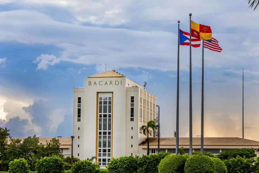 Edificio de BACARDÍ en Cataño, Puerto Rico, con banderas bajo un cielo azul