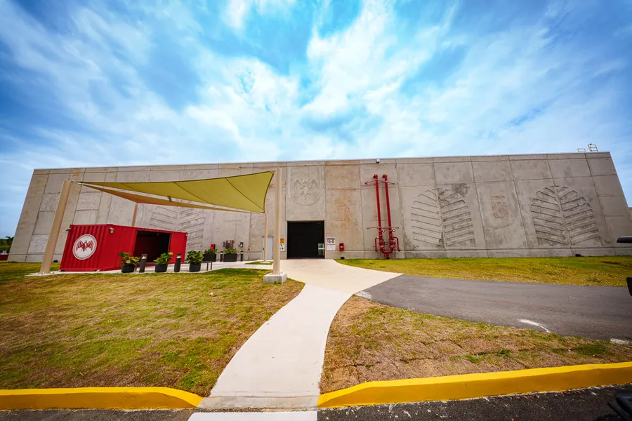 Nuevo almacén de añejamiento de BACARDÍ en Cataño, Puerto Rico: edificio de hormigón con entrada y toldo